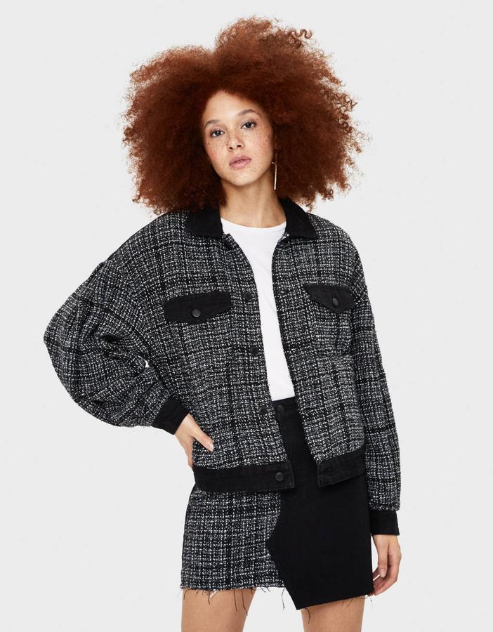 Chaqueta tweed combinada con denim negro de Bershka. Costaba 39,99 euros y está rebajada a 24,99 euros.