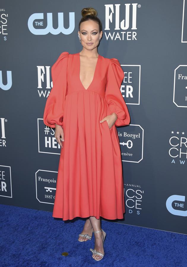 Olivia Wilde escogió un diseño midi y se enfundó este vestido de mangas abullonadas y falda acampanada color coral de Valentino.
