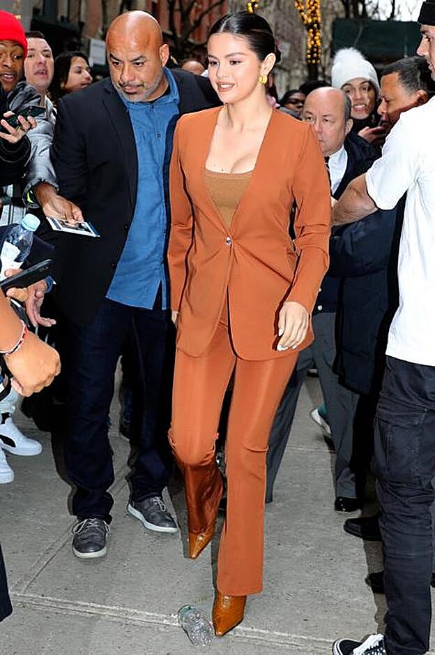 Selena Gomez con un traje anaranjado.
