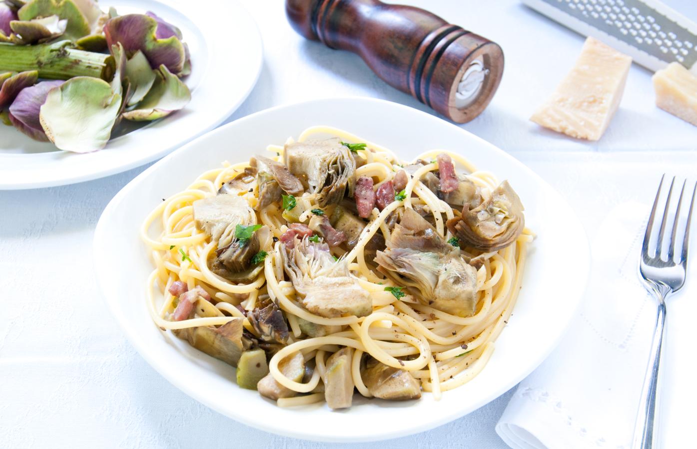 Otra receta express que soluciona cualquier comida. Hierve la pasta y escúrrela. Saltea las alcachofas con cayena en la sartén, salpimenta y añada bacon. Cuando esté dorado, vierte la pasta con algo de liquido de la cocción y... voilá!