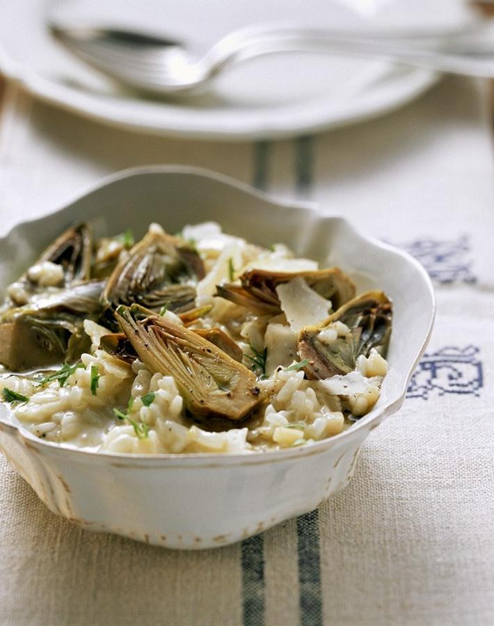Necesitas arroz blanco y alcachofas para este risotto. Además: necesitarás queso parmesano, ajo, cebolla, caldo de verduras y limón. Sofríe la cebolla con la alcachofa y el ajo. A continuación, añade el arroz y sofríelo junto a la verdura. Una vez mezclado, añade poco a poco el caldo de verduras. Mientras espesa, añade parmesano para un textura más cremosa. Salpimenta, escurre unas gotas de limón. ¡Bon Appétit!
