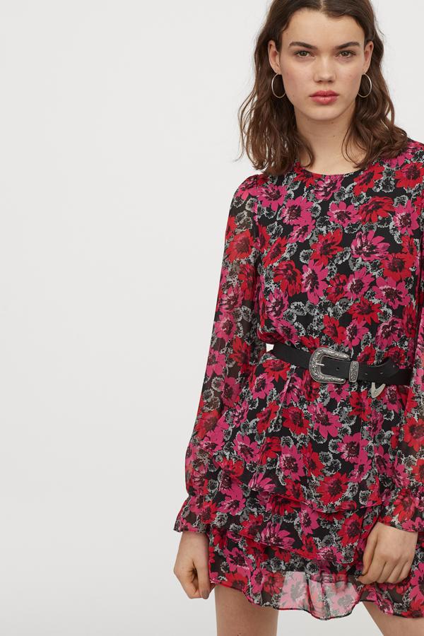 Rosa, rojo y gris sobre fondo negro para este vestido corto de gasa estampada con escote redondo y volantes en la parte de la falda. Cuesta 24,99 euros y está disponible en H&M entre las tallas 32 y 46.