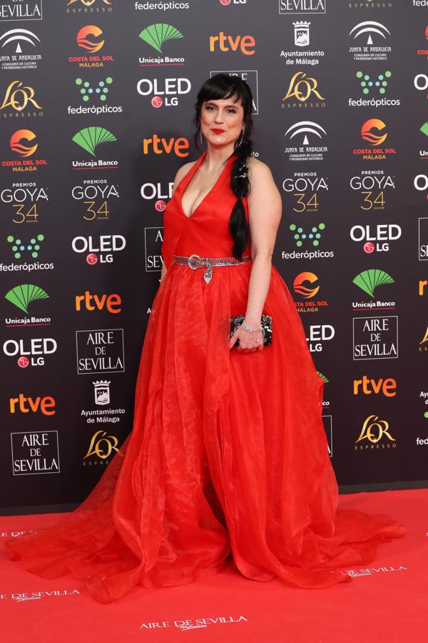 Laura Zamora con un vestido rojo con falda vaporosa, escote en pico y cinturón plateado poco acertado.