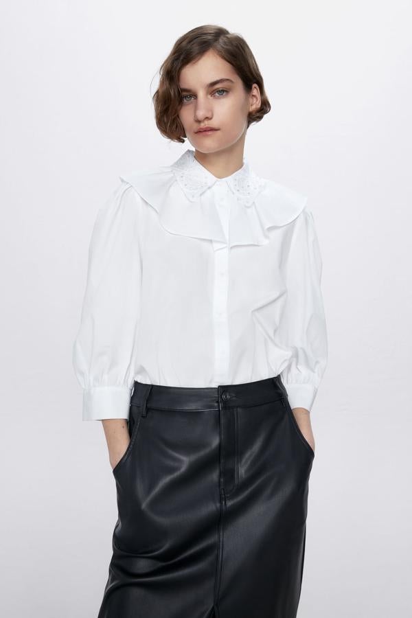 Con cuello solapa bordado y manga abullonada por debajo del codo, este cuerpo con volante al cuello en color blanco es de Zara, cuesta 25, 95 euros y está disponible entre las tallas XS y XXL.
