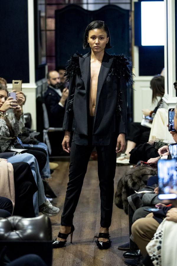 Del desfile de Otrura destacó este traje negro con hombreras adornadas con plumas.