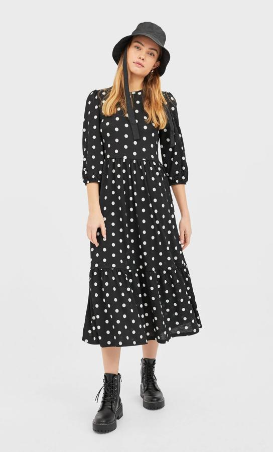 Vestido midi negro con lunares blancos rematado con volante en el bajo, de la nueva colección de Stradivarius (17.99 euros).