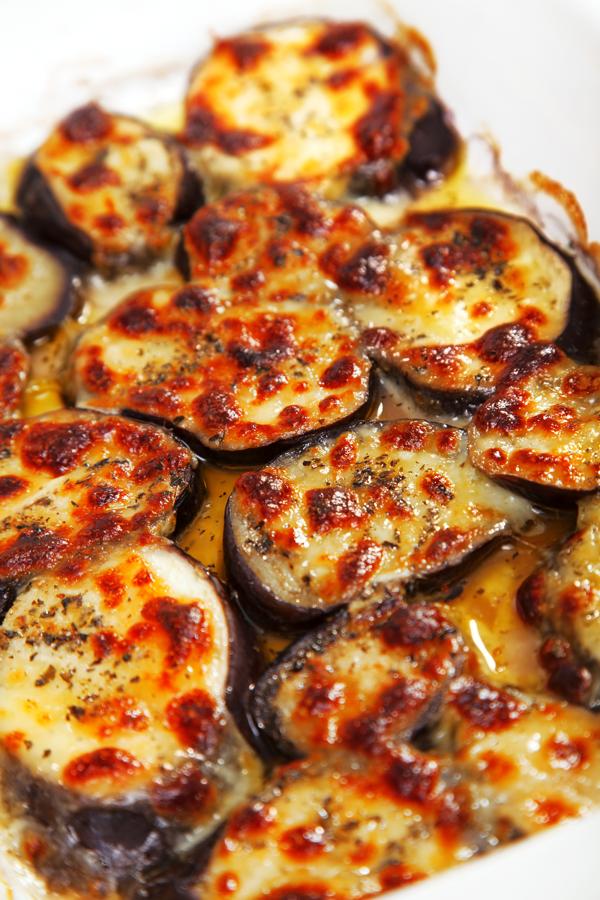 Sencilla, rápida y con pocas calorías. Corta la berenjena en rodajas y ponla en una bandeja de horno. Métela al horno durante 15 minutos a másxima potencia y después, pon mozarella light encima y adereza con sal, pimienta y óregano. Vueñeve a introducir la bandeja en el horno hasta que la berenjena esté al punto y el queso fundido. Aliña con aceite de trufa... ¡Y listo!