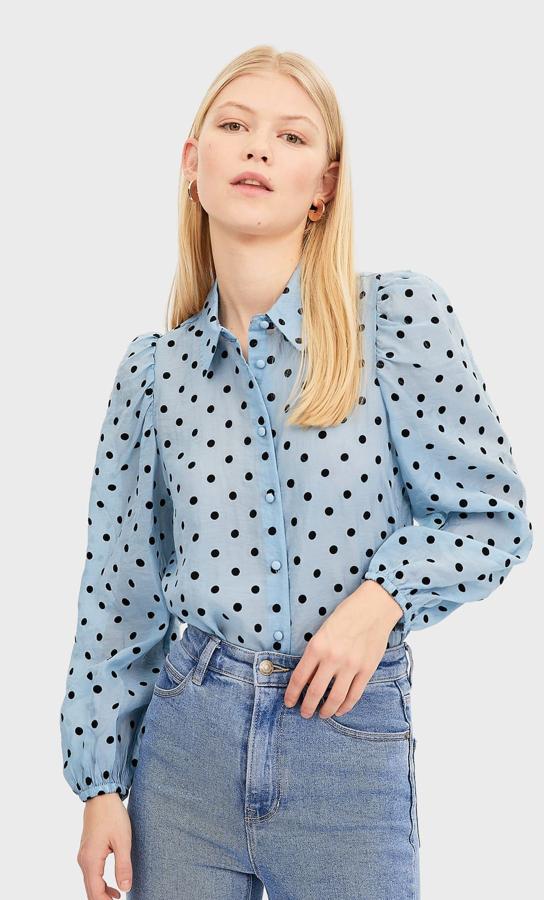 Si eres una enamorada de los lunares este blusa azul transparente es perfecta para huir del clásico binomio 'black and white'. De Stradivarius, (15,99 euros).