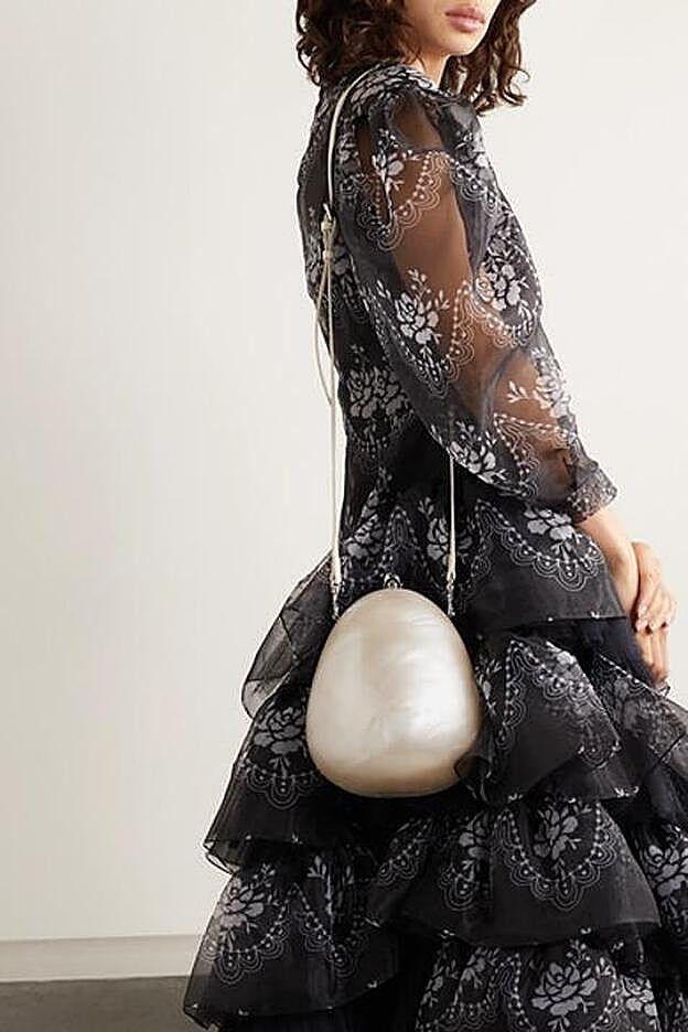 Al hombro, con la correa larga.