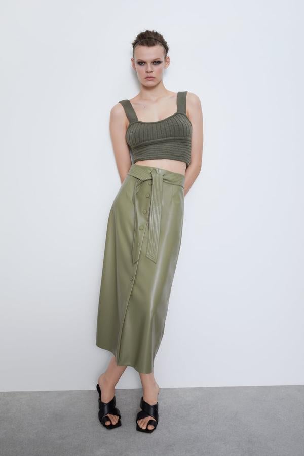 Uno de los últimos diseños que ha llegado al catálogo de Zara es esta falda midi con elástico en la espalda, en línea evasé y cinturón combinado a tono. En un primaveral verde oliva, esta falda cuesta 39,95 euros y solo queda en las tallas M y L en la web.