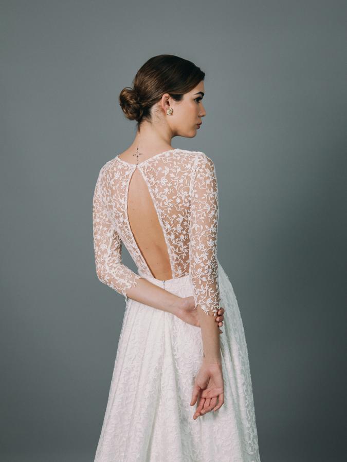 Vestido de novia con favorecedor cuerpo entallado y escote en “V”. Manga francesa y falda de capa con cola. Confeccionado en fino guipur sobre base de tul.