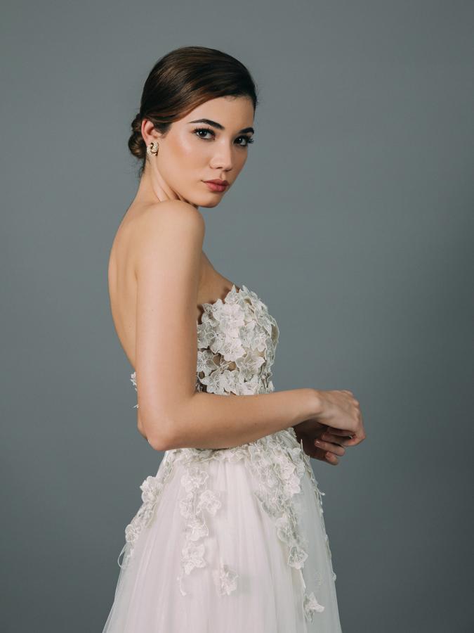 Vestido de novia con cuerpo de corsé confeccionado con aplicaciones bordadas a mano. Corte en la cintura y falda de tul con cola.