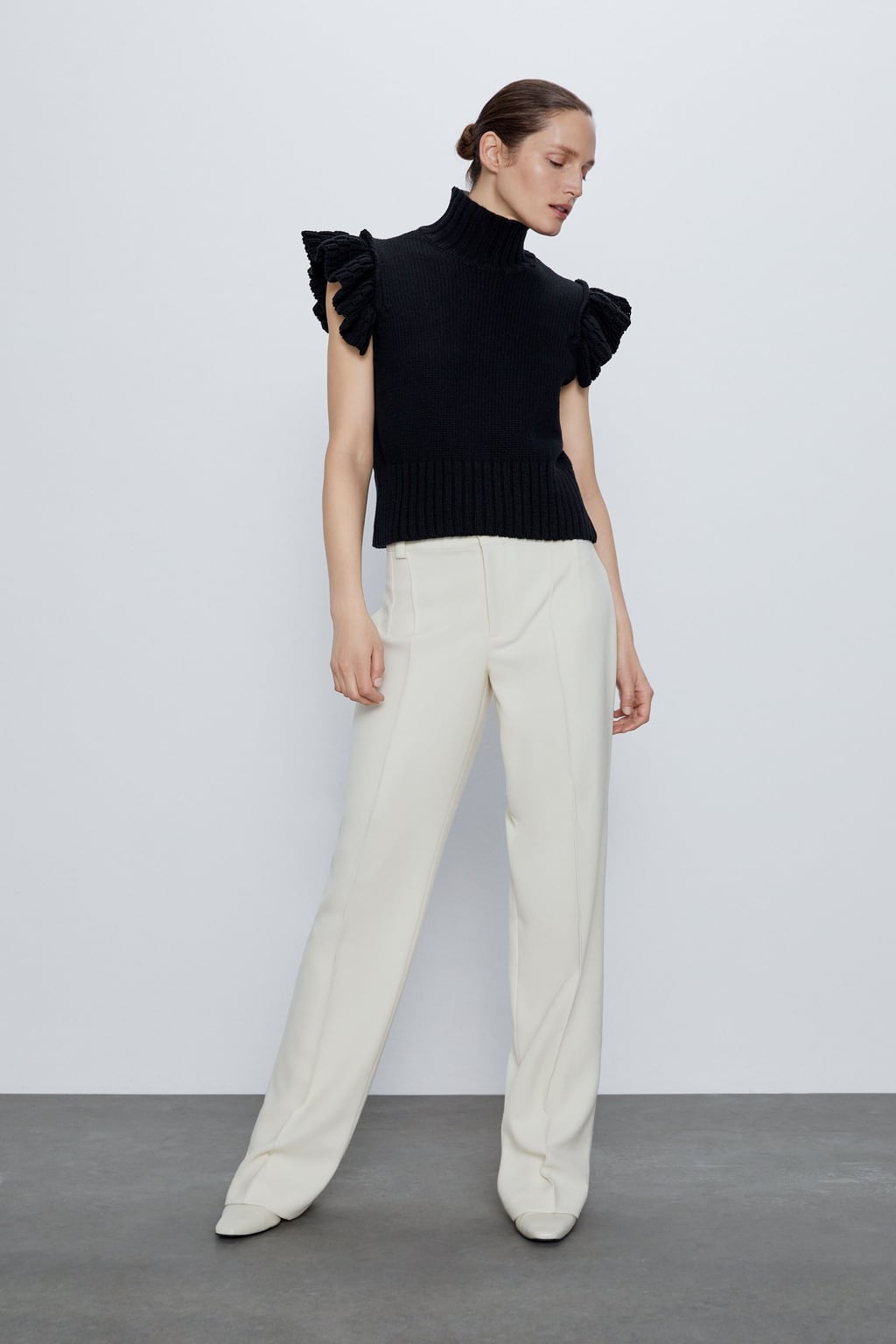 Jersey negro de punto y manga corta con cuello y volantes. ¿Es o no es un capricho? (22,95 euros).