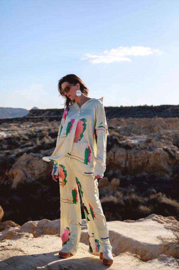 Macarena Gómez para la nueva colección Studio de H&M con un conjunto de camisa oversize y pantalón estampado de satén combinado con botas de piel de plataforma y pendientes 'disco'.