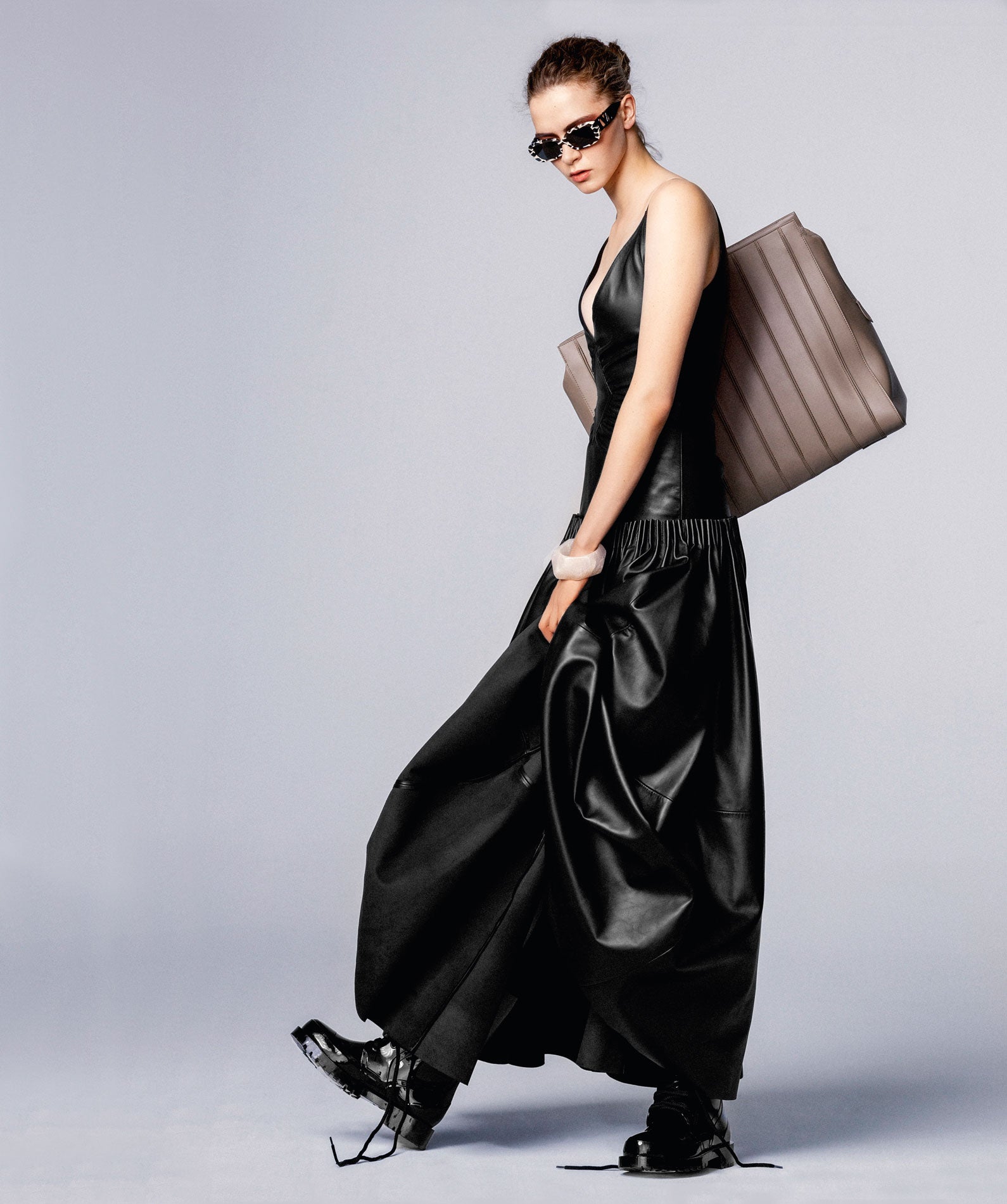 Vestido de cuero, de Loewe; botas de Dior, bolso Whitney de Max Mara, gafas de Valentino, y pulsera de Emporio Armani.