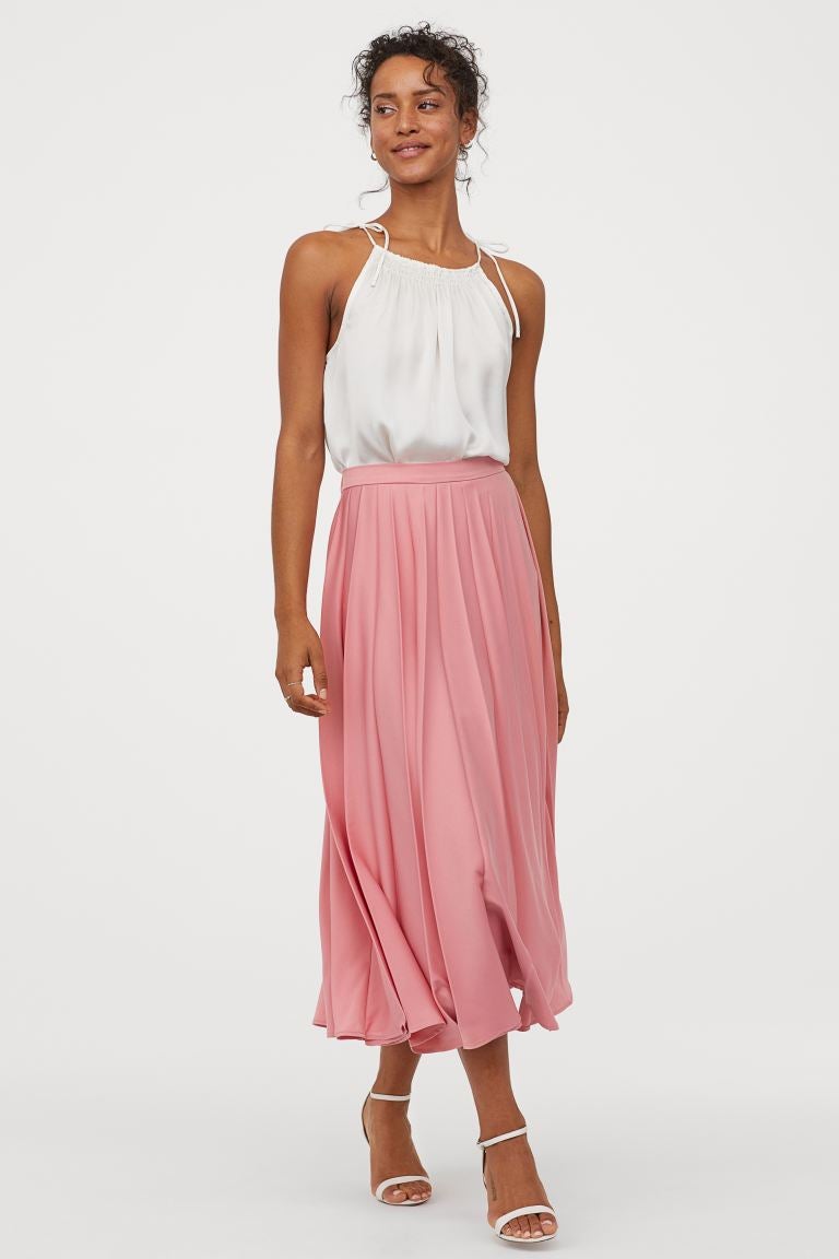 Falda plisada en tejido rosa de satén de H&M. (49,99 euros).