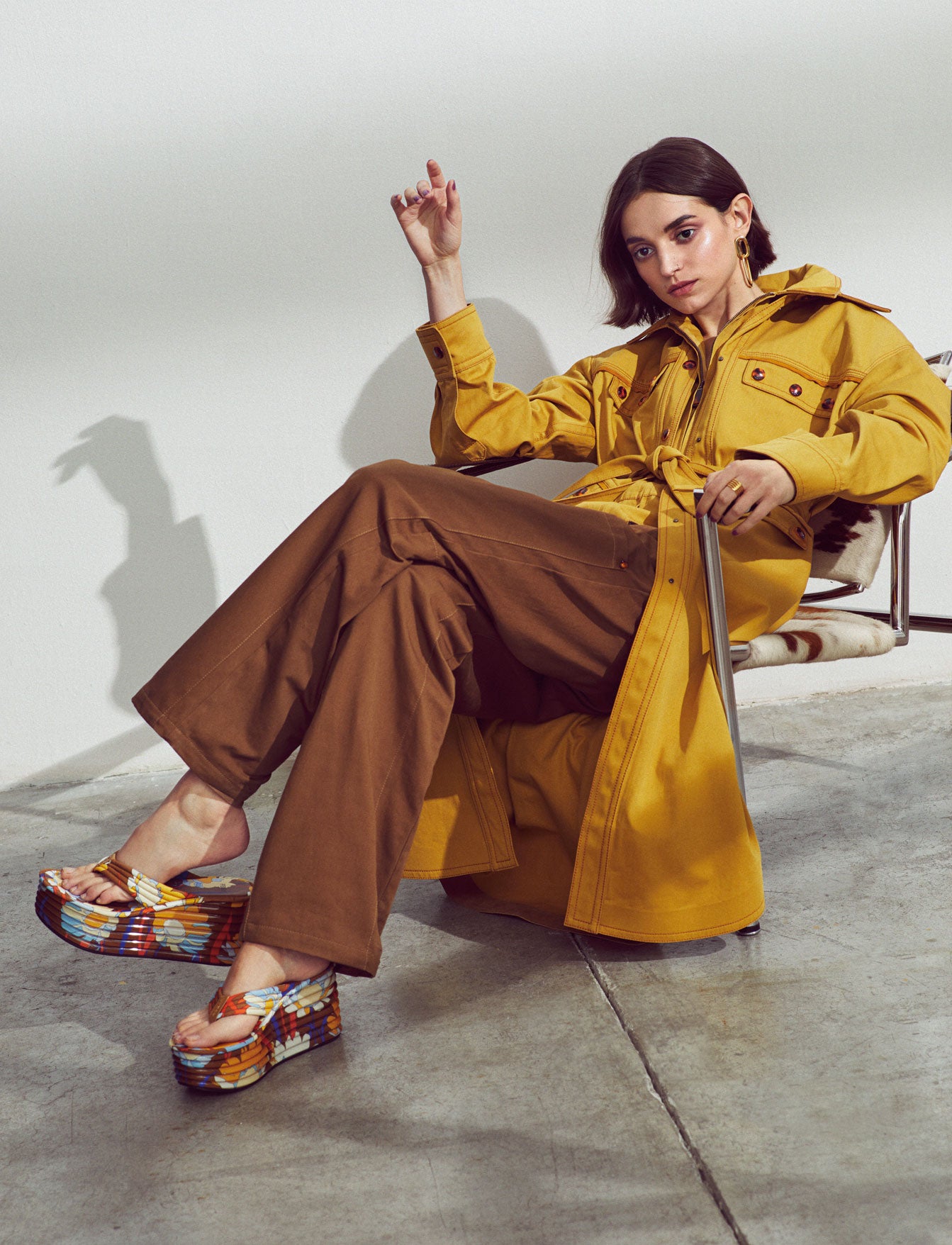 Gabardina, mono y sandalias, todo de Fendi. El pendiente y el anillo son de Agatha Paris.