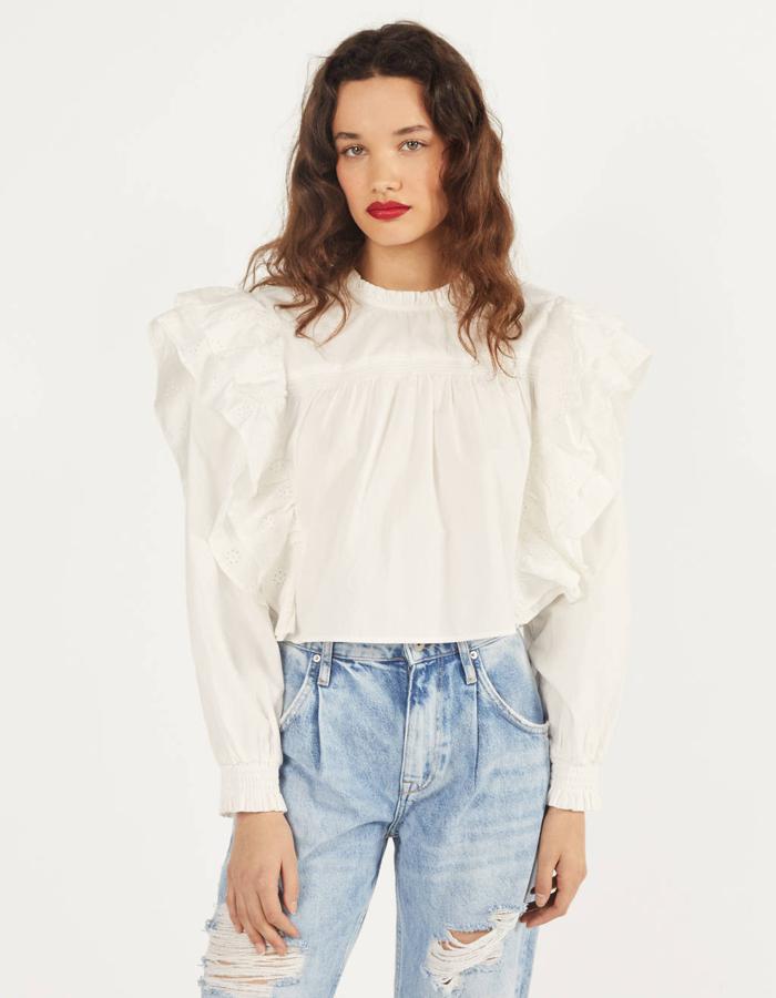 En Bershka hemos encontrado este diseño cropped con volantes en los hombros que tienen bordado suizo. Si lo tuyo son este tipo de aplicaciones, esta prenda es esencial en tu armario. Cuesta 25,99 euros y está disponible entre las tallas XS y L.