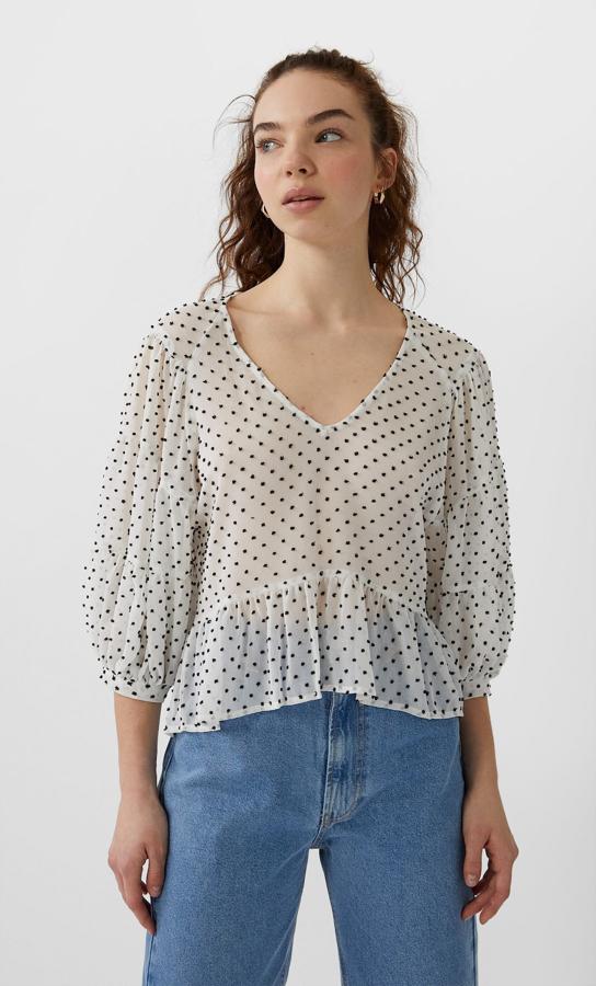 En esta selección no podía faltar el plumeti, aunque venga a contraste. Esta blusa blanca péplum con detalles negros de plumeti es de Stradivarius, cuesta 17,99 euros y está disponible en las tallas S, M y L.