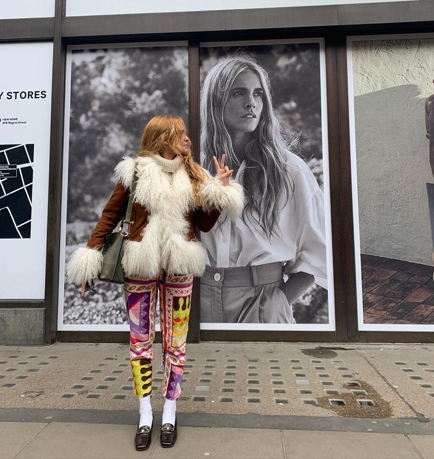 Otra vez su chaquetón setentero que ahora combina con unos pantalones multicolor vintage de Dolce & Gabbana. Y no contenta con eso, le pone a sus mocasines unos calcetines blancos. ¿De locos? No, de genios. Y detrás, en la foto, ella misma protagoniza una campaña publicitaria.