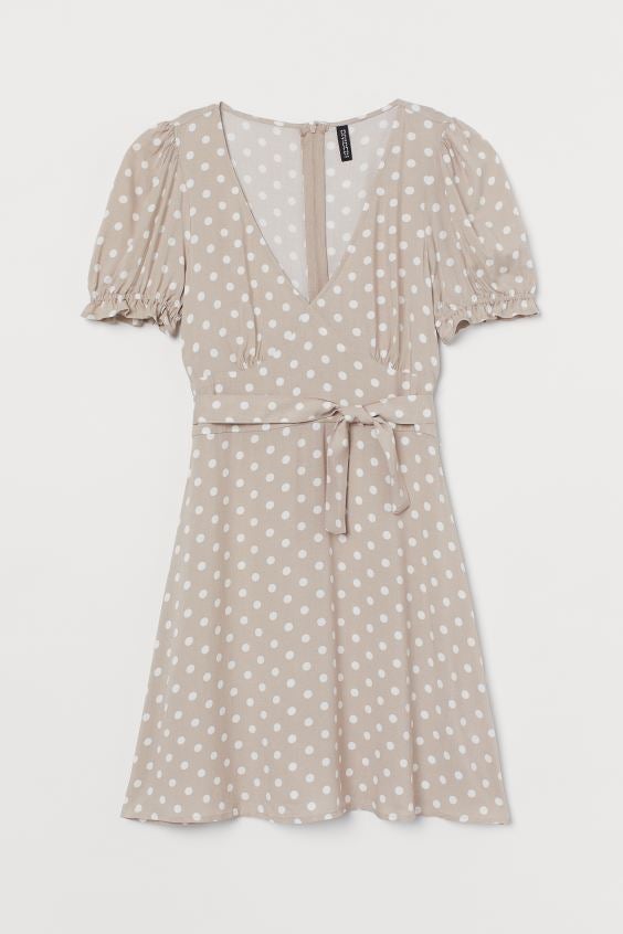 Vestido de lunares en tono beige con escote a pico, mangas farol y cinturón ajustable. De H&M. (14,99 euros).