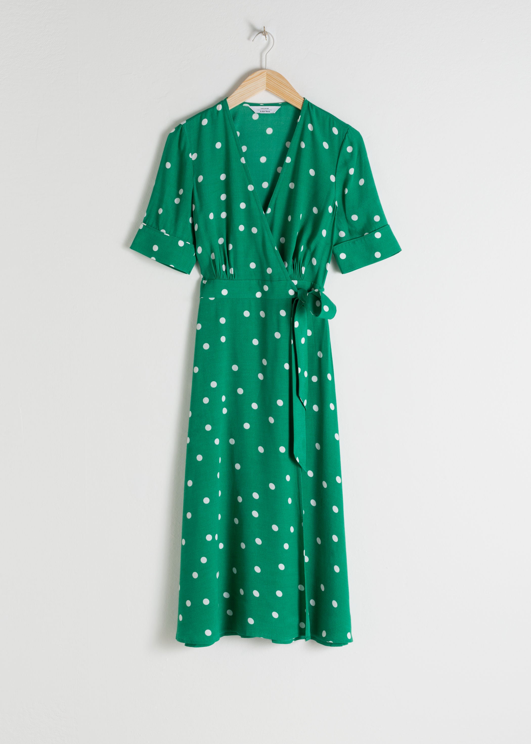 El tono verde vuelve a colarse esta primavera con prendas tan bonitas y favorecedoras como este vestido midi cruzado de & Other Stories. (79 euros).