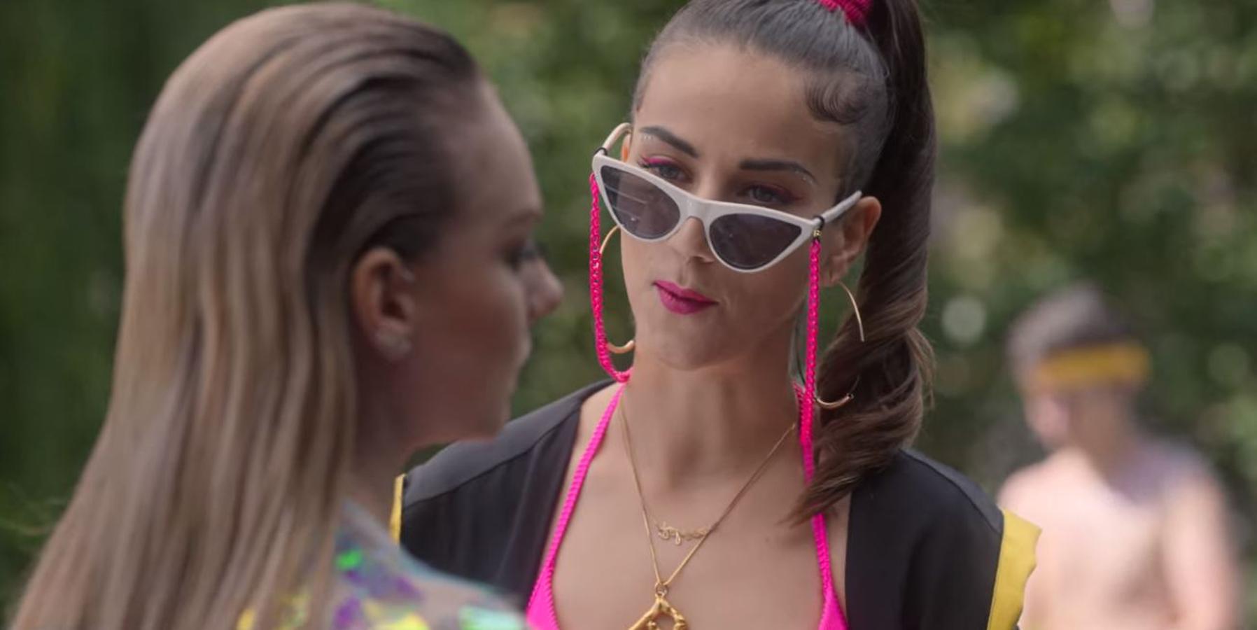 ¿Combinar el eyeliner con el labial? Claudia Salas, que interpreta a Rebeca, demuestra en uno de los capítulos que es todo un acierto. Y lo hace en color rosa fucsia combinado así su maquillaje con la correa de sus gafas y el top.