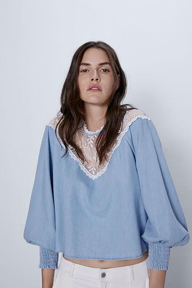 Espectacular blusa azul con el cuello adornado por una pieza de organza bordada.