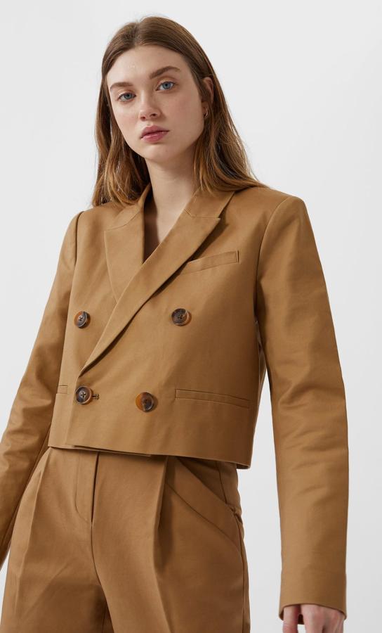 Esta americana crop en color beige y con doble botonadura, te hará ganar visualmente algunos centímetros. Es de Stradivarius, cuesta 29,99 euros y está disponible en las tallas S, M y L.