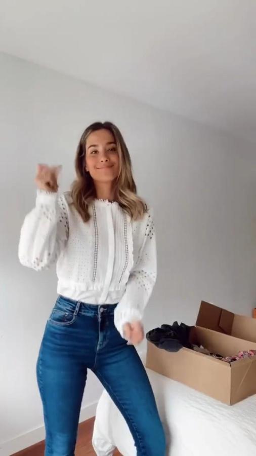 Blusa blanca con bordados (25,95 euros) y pantalones vaqueros de corte flare (25,95 euros).