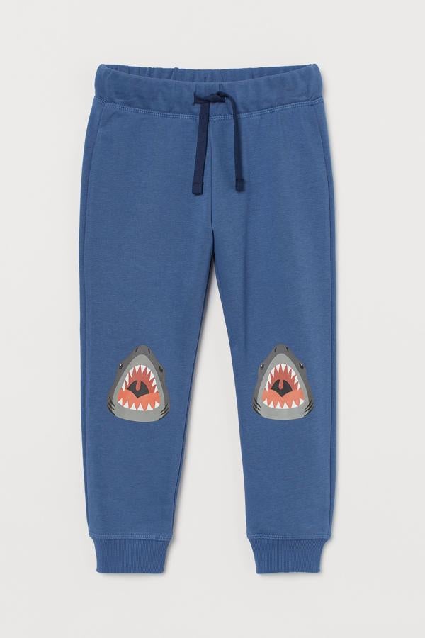 Si van a estar en casa muchos días, nos guste o no, tienen que ir cómodos,. Estos pantalones jogger de H&M con rodilleras de tiburones cumplen con esa función. Y tienen su gracia.
