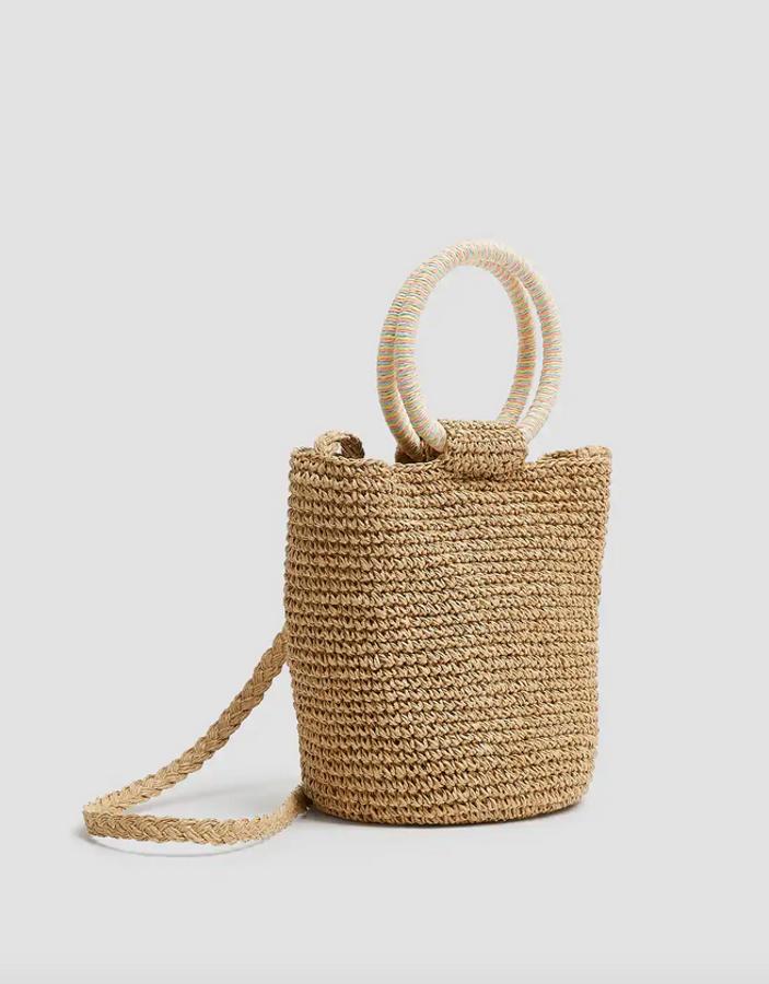 Una de las propuestas más estilosas de Pull & Bear es esta bandolera de rafia beige con asas redondas en crudo. Cuesta 15,99 euros.