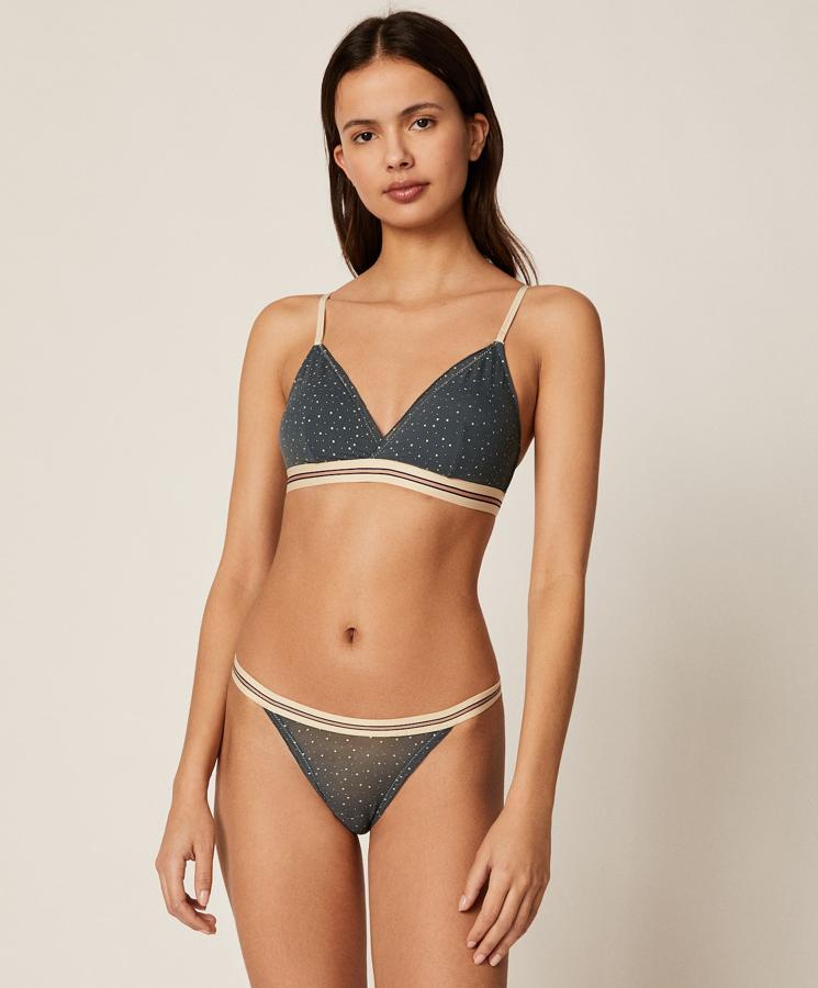 Este conjunto en gris oscuro de Oysho es de los que conquistan. Formado por sujetador triangular en tejido de tul con estampado de estrellitas y detalle de goma elástica en la parte inferior, tiene relleno extraíble y un precio de 16,99 euros. A juego está la braguita de tira con un precio de 6,99 euros.