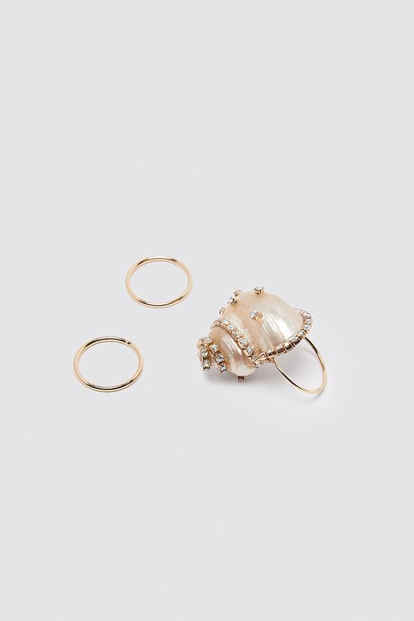 No puedes perderte este pack de tres anillos metálicos, uno de ellos con una aplicación de caracola con detalles joya. Tiene un precio de 12,95 euros.