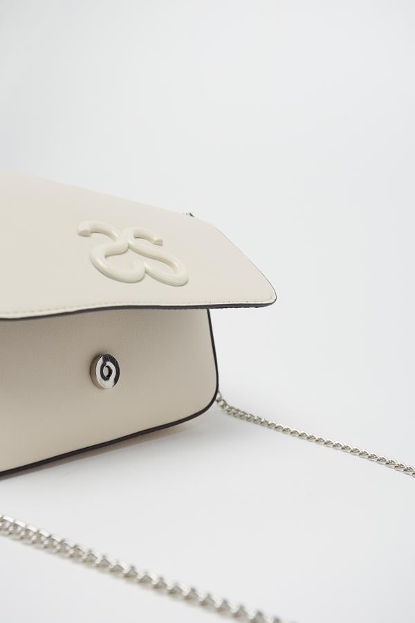 Esta bonita bandolera con asa larga de cadena e interior en color negro viene con dos bonitas eses en la solapa porque es de Sfera. Cuesta 16,99 euros.