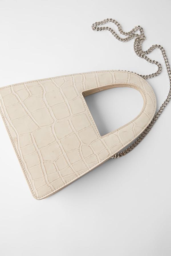 Una de nuestras propuestas favoritas es esta bandolera con estampado animal y asa cut out de Zara que cuesta 25,95 euros y es ideal para tus looks más elegantes.