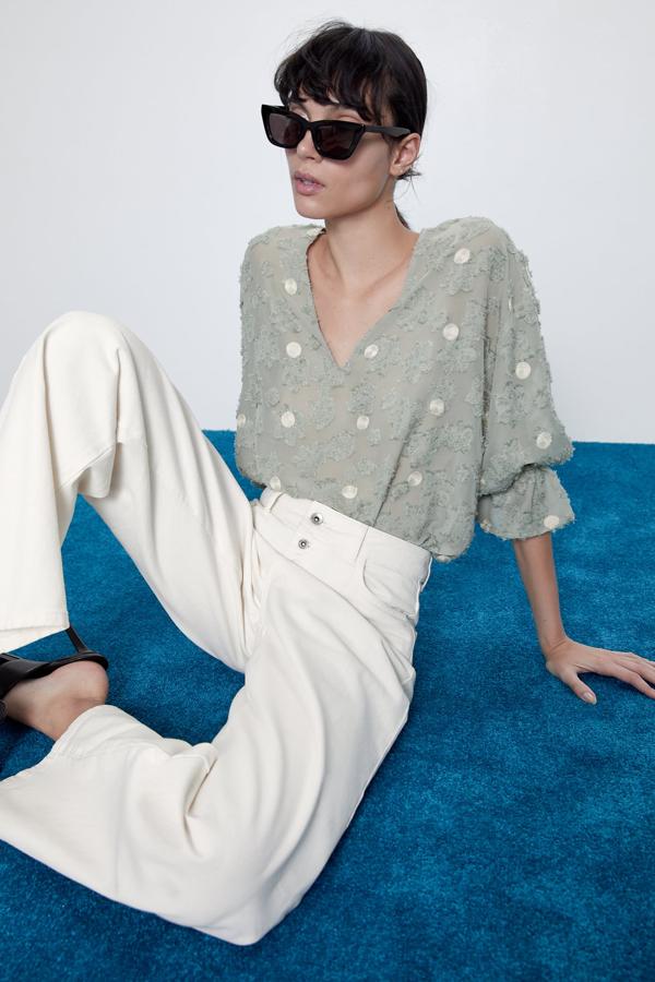 Zara nos propone esta original camisa semitransparente con escote de pico y manga con elástico y volante al codo. Tiene un precio de 25,95 euros y está disponible de la talla XS a la XL.