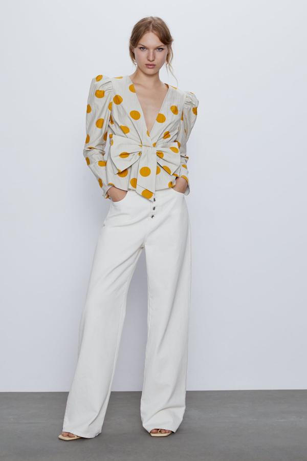Para las más atrevidas, Zara nos propone esta camisa con escote de pico y manga abullonada en el hombro. Con grandes topos amarillos, la clave del diseño es el gran lazo delantero. Actualmente solo está disponible en las tallas XS, S y M y tiene un precio de 29,95 euros.