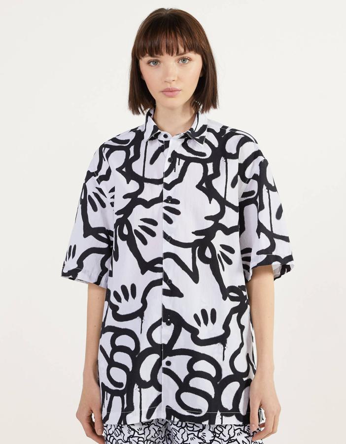 Camisa oversize blanca de algodón con dibujos de la mano de Mickey Mouse. Uno de los ‘best seller’ de Bershka, disponible en las tallas S, M y L y que cuesta 25,99 euros.