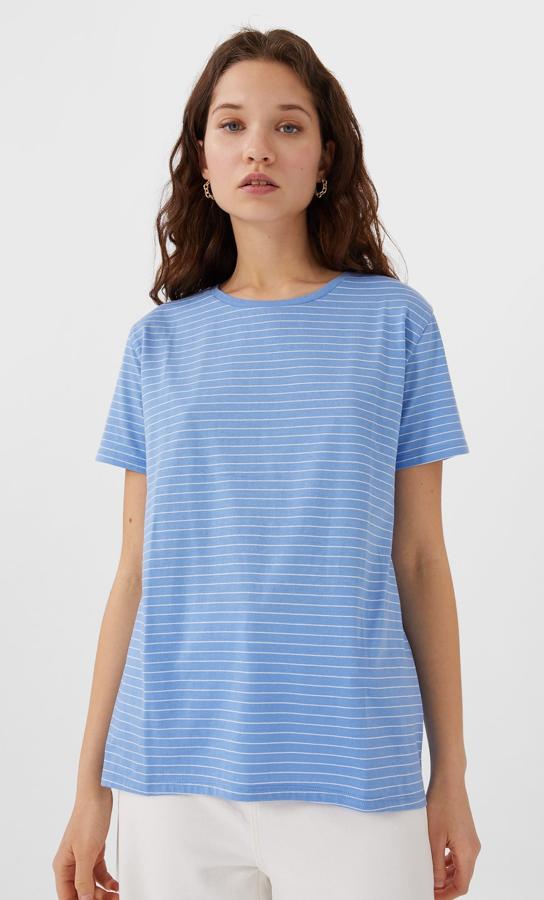 Stradivarius nos propone una camiseta de corte clásico y manga corta en color azul claro con finas rayas en blanco. Disponible de la talla XS a la L, tiene un precio genial, 5,99 euros.
