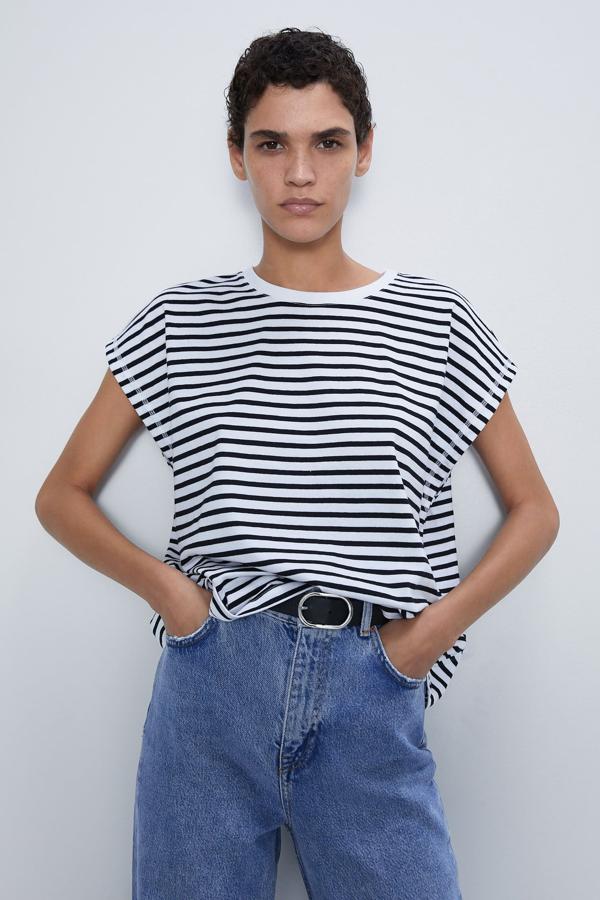 Con algodón 100% orgánico, esta camiseta con cuello redondo y manga sisa cuenta con rayas en negro. Con detalle de costuras vistas, es de Zara y está disponible de la talla S a la XL. Tiene un precio de 7,95 euros.