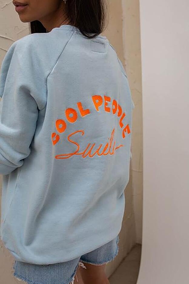 La sudadera azul bebé de Tipitent tiene un original bordado naranja en la espalda.