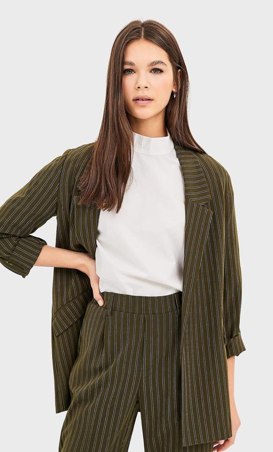 Las blazers nunca pasan de moda, y Stradivarius nos propone esta en tejido fluido en color kaki con rayas verticales que estiliza la figura al máximo. Tras el descuento que ofrece la marca, tiene un precio de 12,99 euros.