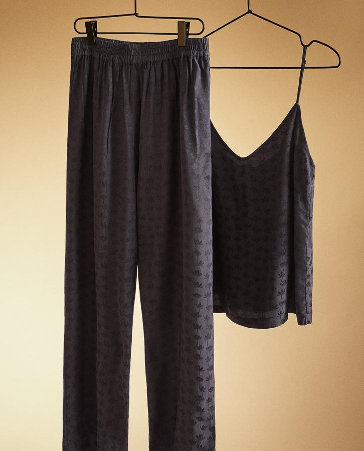 Este pijama de Zara Home está volando. Formado por pantalón ancho de color negro con jacquard de hojas, tiene un precio de 29,99 euros. A juego encontramos la camiseta de tirantes, que cuesta 19,99 euros.