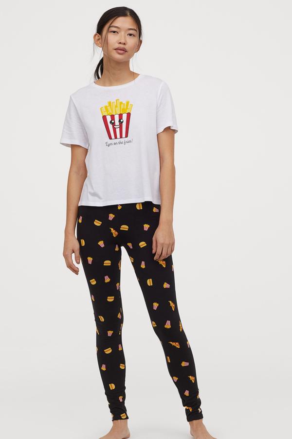 H&M nos propone este divertido pijama de dos piezas en punto suave, con camiseta en color blanco con estampado de patatas fritas y leggins en negro con dibujos de patatas y hamburguesas. Tiene un precio de 19,99 euros.