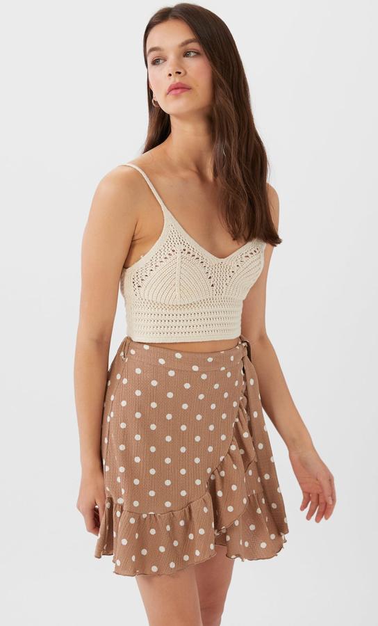 Beige con pequeños topos en blanco, esta minifalda con volantes de Stradivarius te resultará de lo más cómoda. Con un precio de 12,99 euros, está disponible desde las tallas XS a la L.