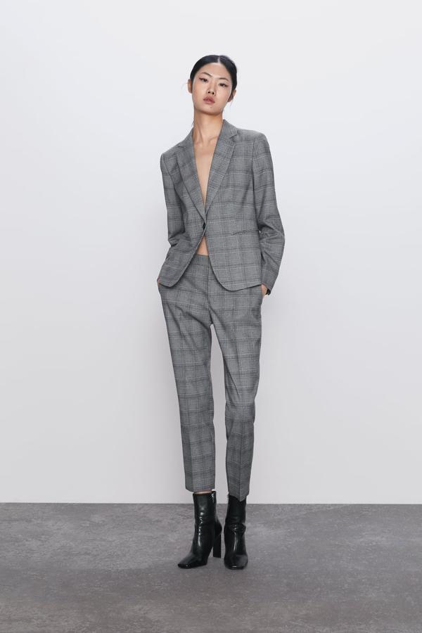 En color gris, con cuadros en todos azulados y blancos, esta blazer de Zara tiene bolsillos delanteros de doble vivo y cuello de solapa. Cuesta 29,95 euros y está disponible entre las tallas 34 y 46.