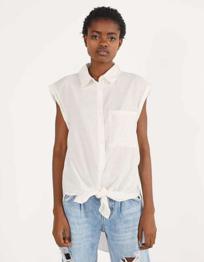 No hay verano sin camisas anudadas a la cintura y en Bershka lo saben bien porque han lanzado esta camisa sin mangas y con cuello de solapa. Disponible en crudo, blanco y rosa, cuesta 15,99 euros y está disponible entre las tallas XS y L.