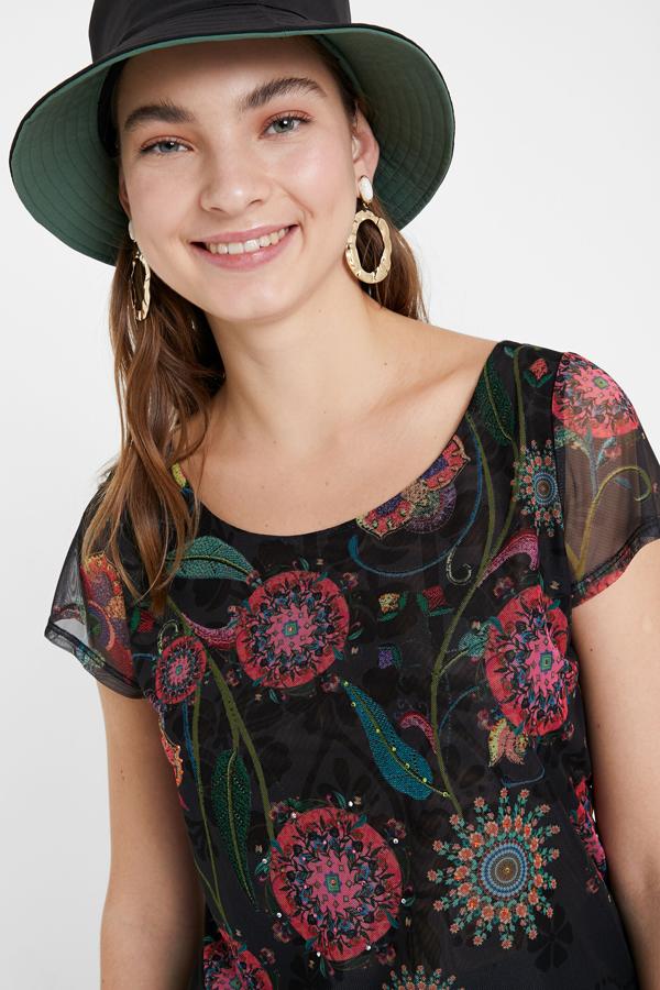 Una camiseta de Desigual tiene muchas señas de identidad y  esta las reúne todas . No solo por su estampado multicolor con fondo negro, también por su patrón y su versatilidad: la puedes llevar de la mañana a la noche (39,95 euros).