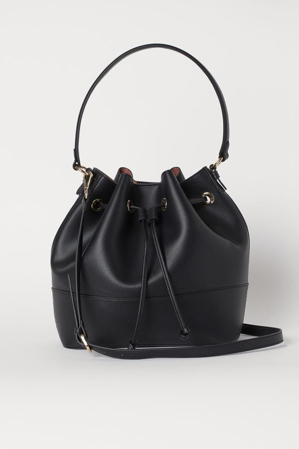 En piel sintética, con asa y correa ajustable extraíble y botón de presión sintética, este bolso de H&M está disponible en negro y marrón y cuesta 29,99 euros.